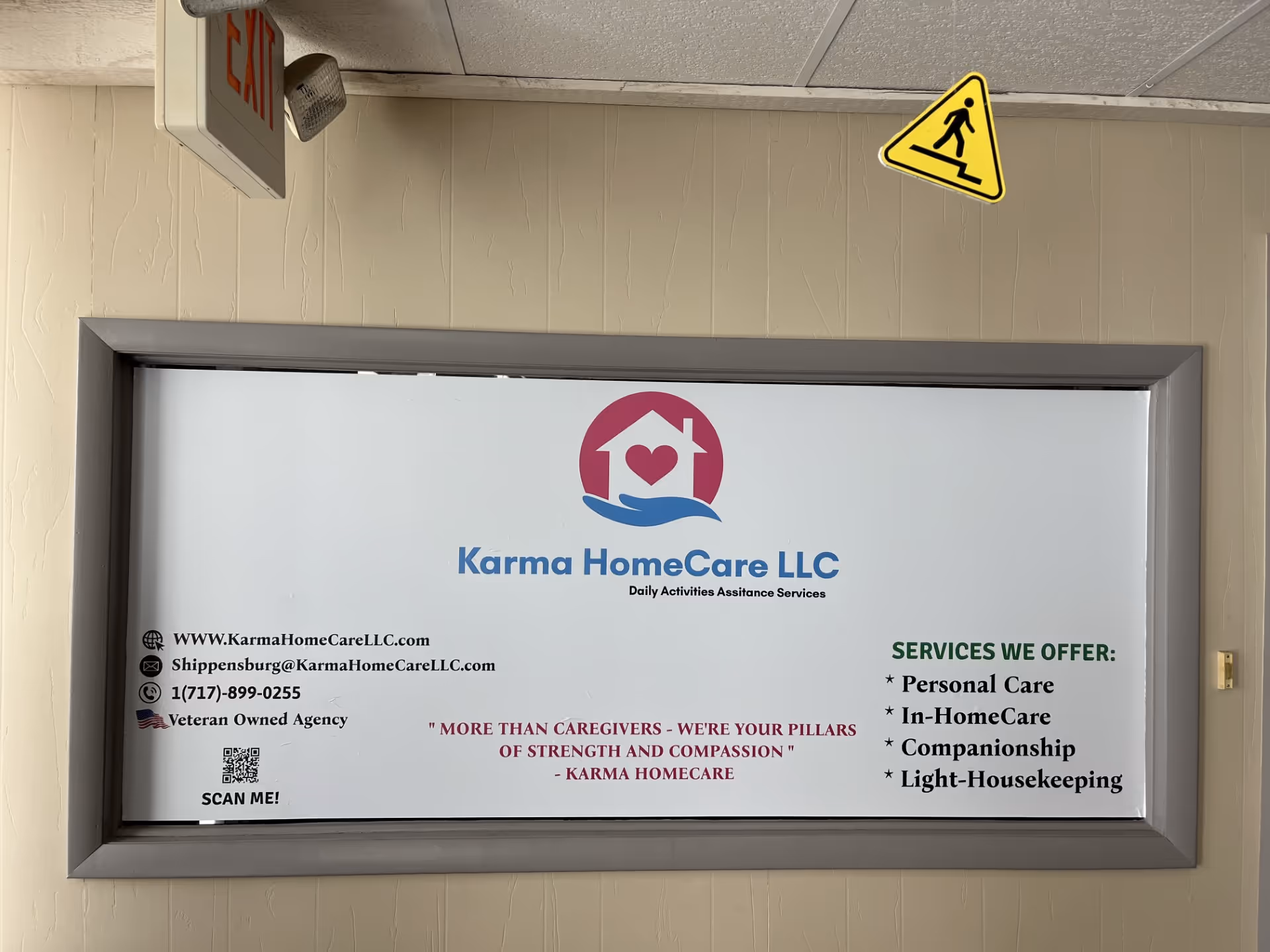 Interior hallway with a framed Karma HomeCare sign and exit sign above.