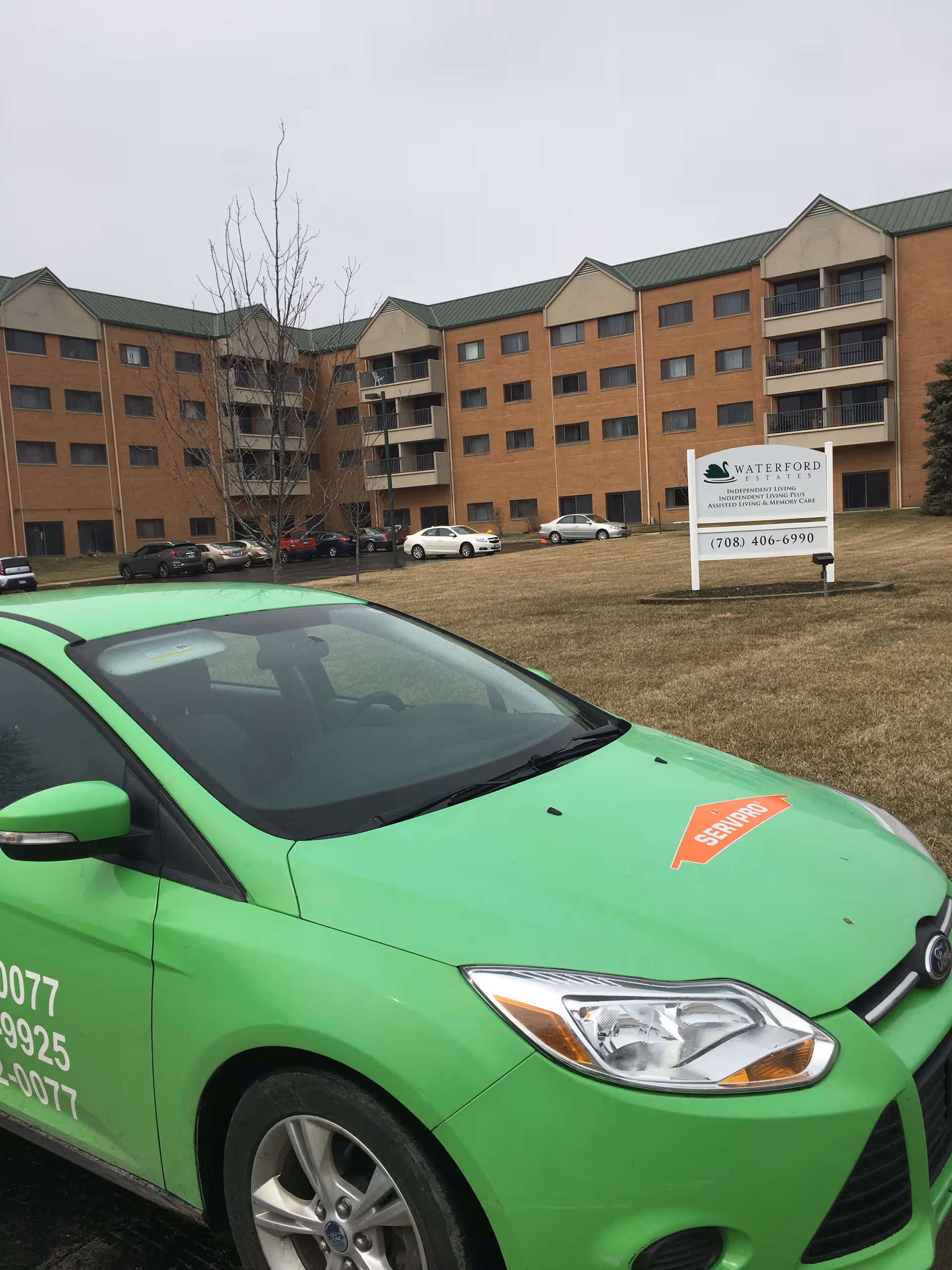 Exterior view of Waterford Estates senior living building with a green car in foreground.