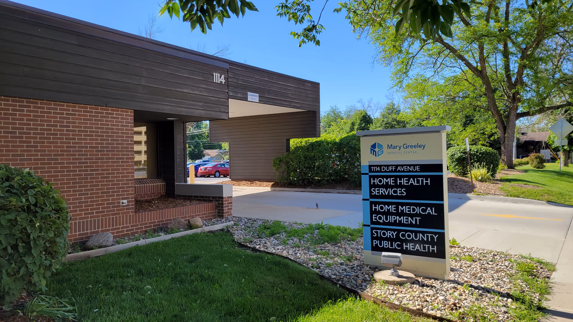 Brick facility entrance with a tall sign displaying Mary Greeley Home Health Services.