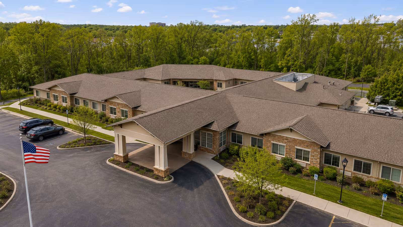 Aerial view of Windsor Heights Assisted Living and Memory Care building with curved driveway and flagpole.