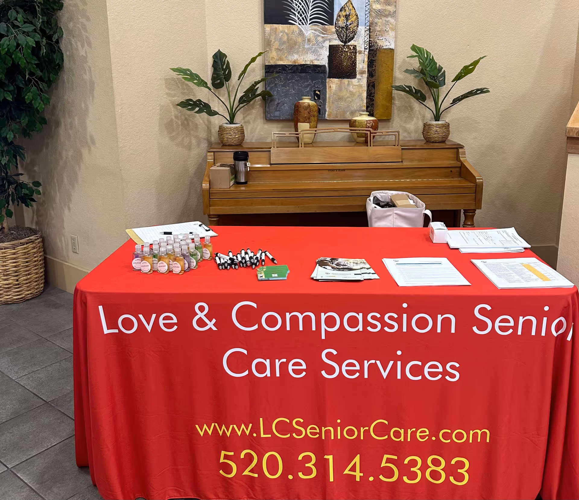 Registration table with Love and Compassion Senior Care Services banner in an interior lobby.