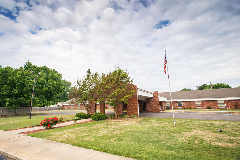 Exterior view of Paris Health and Rehabilitation Center with brick facade, flagpole, and lawn.