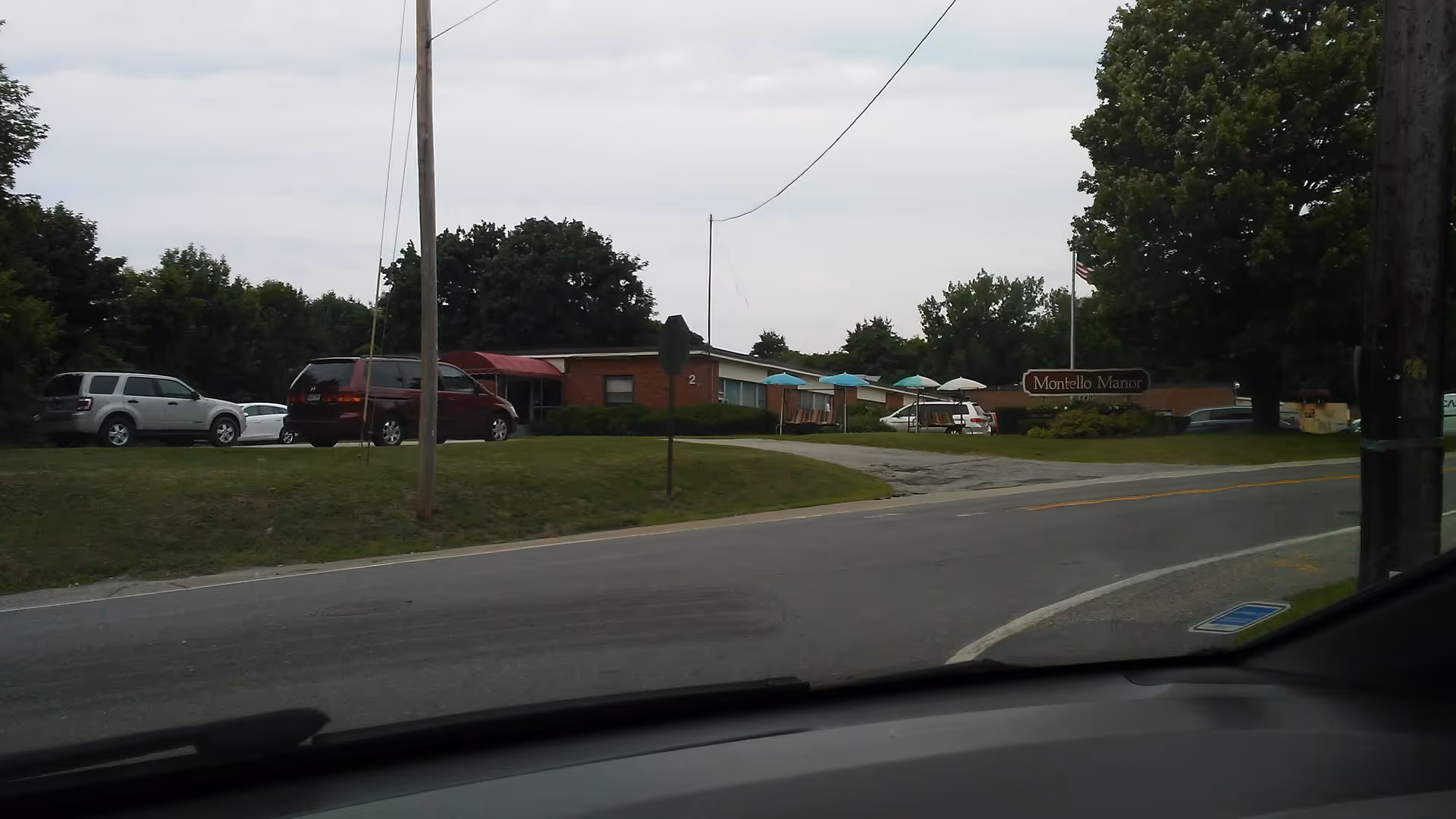 Exterior view of Montello Commons with a brick building, parked cars, and a curved road.