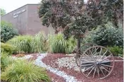 Exterior view of Westmoreland Manor with brick facade, landscaped garden, path, and wagon-wheel decor.