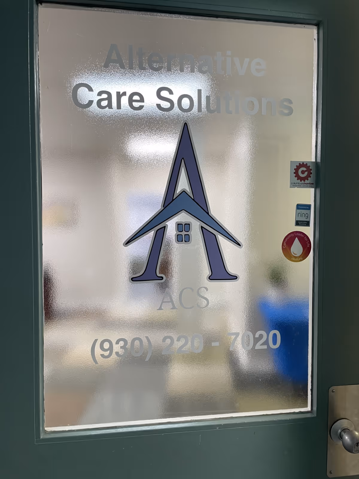 Frosted glass door shows the 'Alternative Care Solutions' logo and phone number.