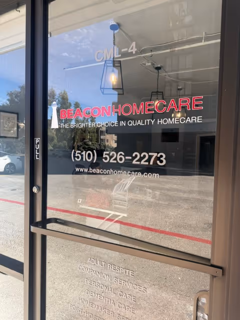 Glass storefront door for Beacon HomeCare with phone number and tagline near entrance.