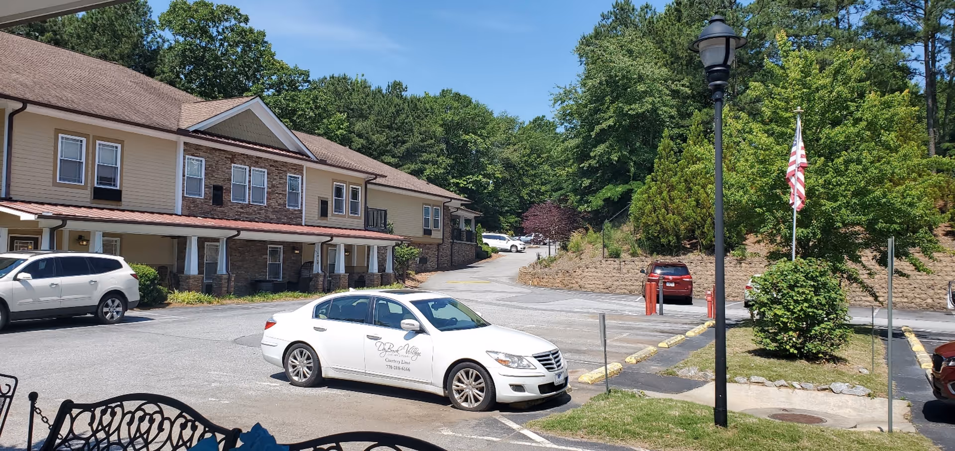 Exterior view of Daybreak Village Assisted Living with parked cars and trees.