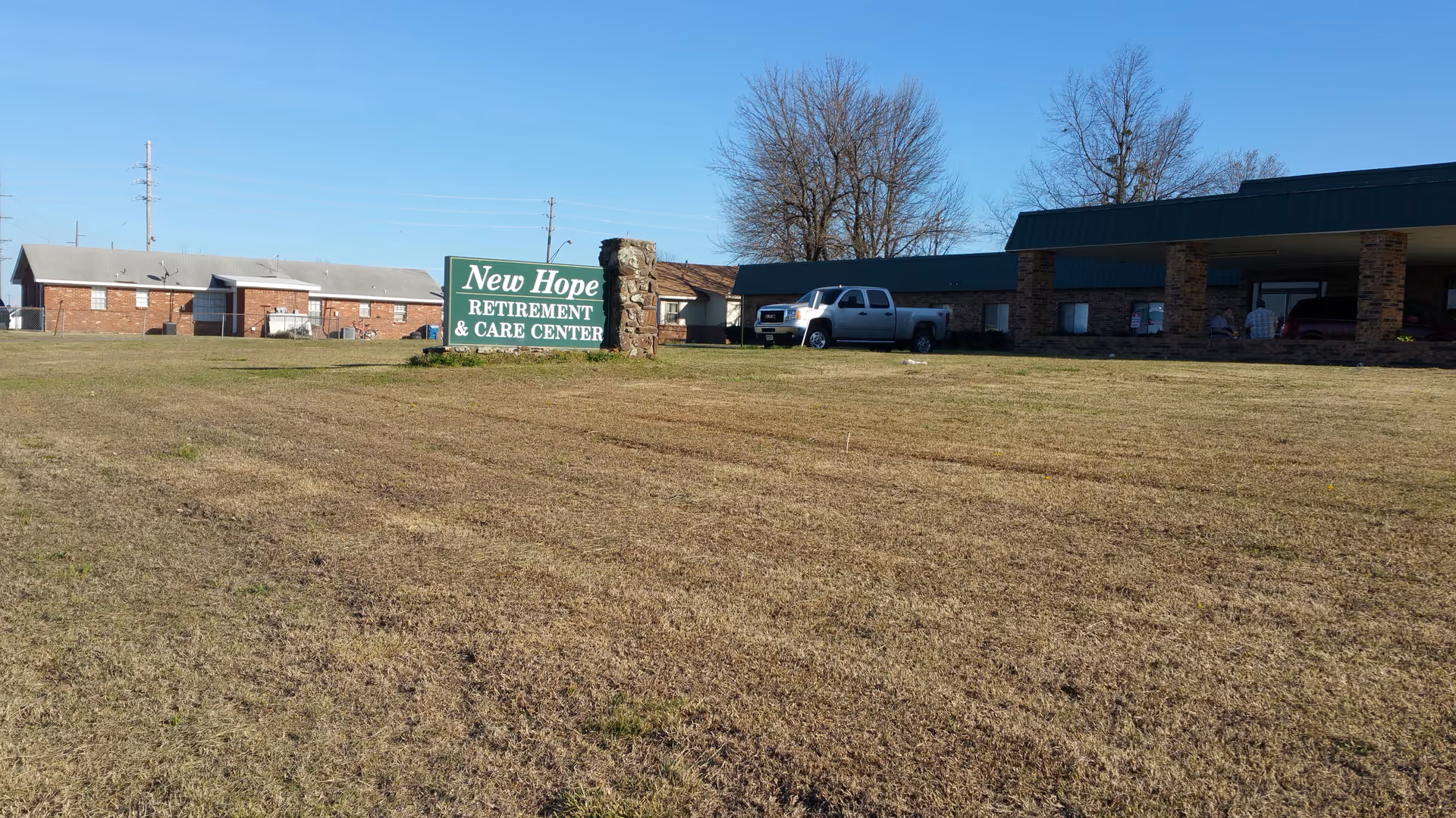 Exterior view of New Hope Retirement and Care Center with sign on a grassy front lawn.