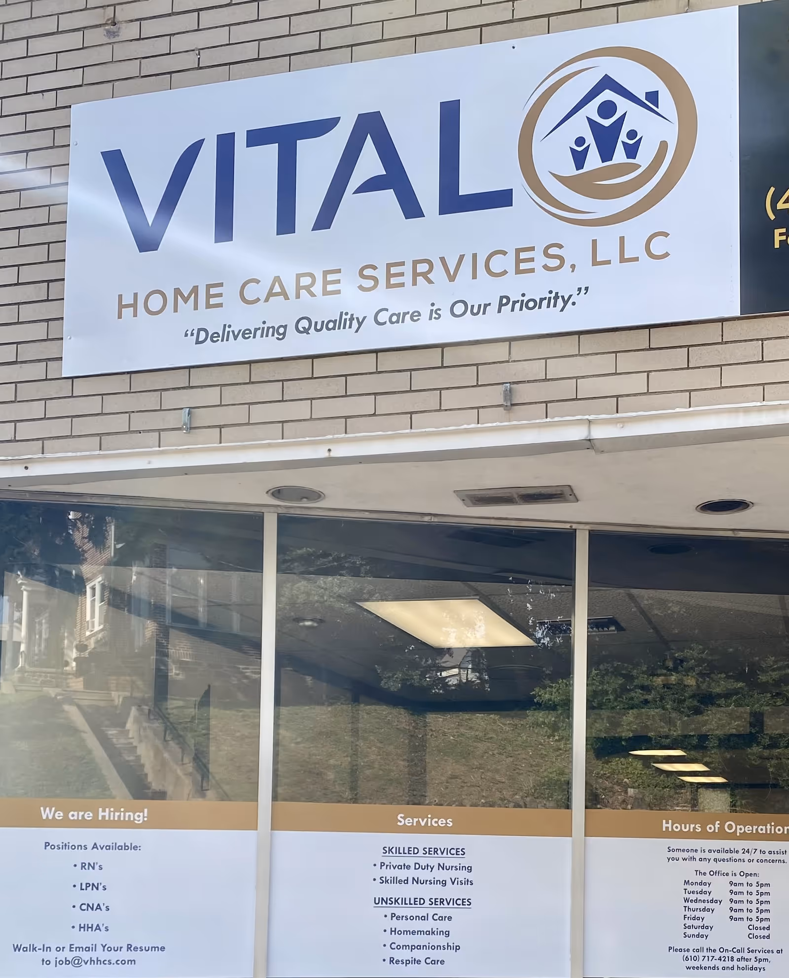 Exterior storefront with Vital Home Care Services LLC sign on brick wall.
