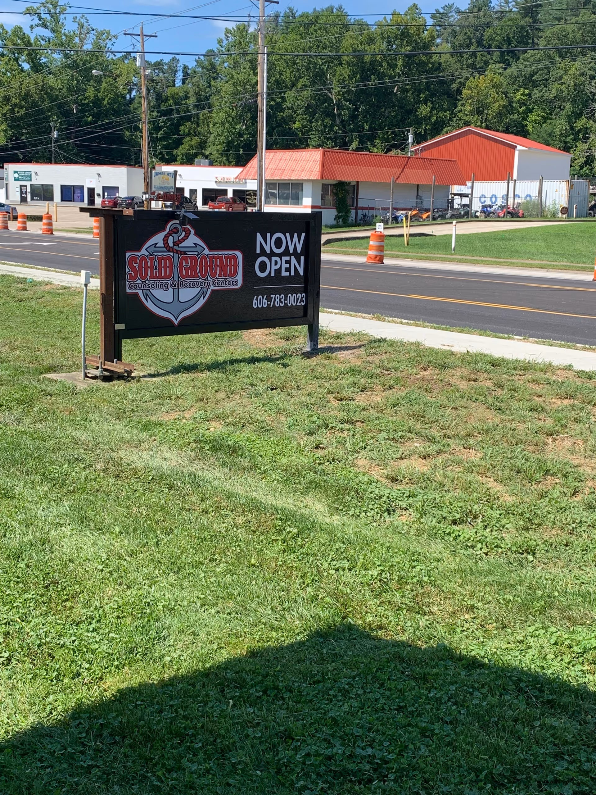 Exterior view of a Solid Ground Counseling & Recovery Centers sign near the street.