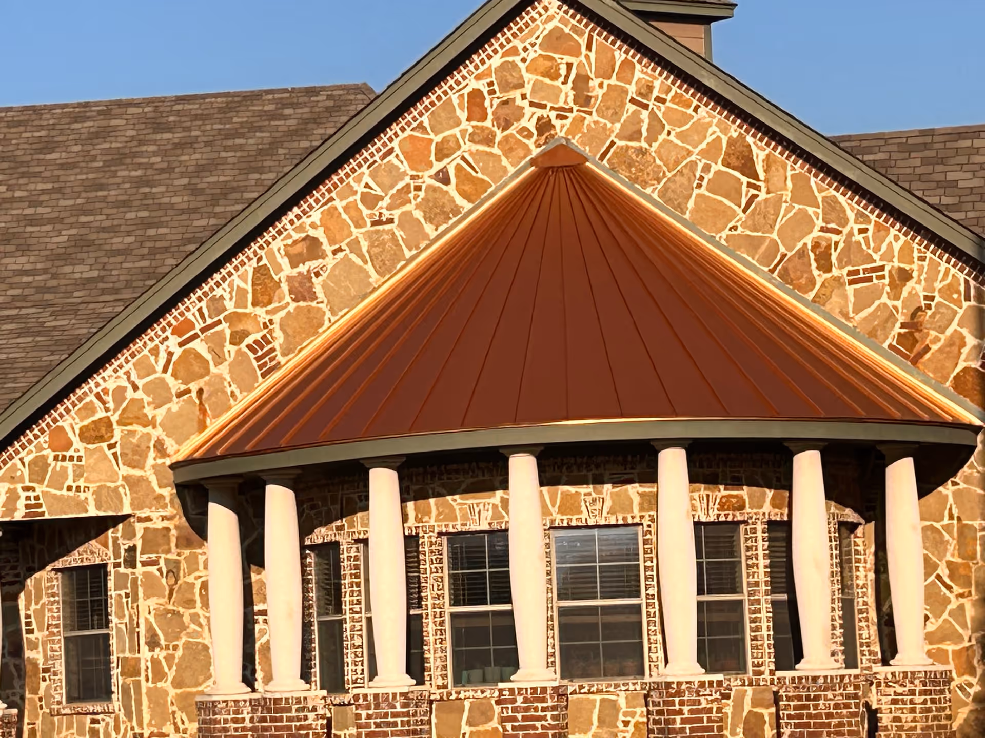 Stone-faced senior living facility exterior with a curved porch and white columns.
