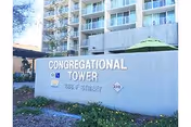 Multi-story residential building with a concrete sign reading Congregational Tower
