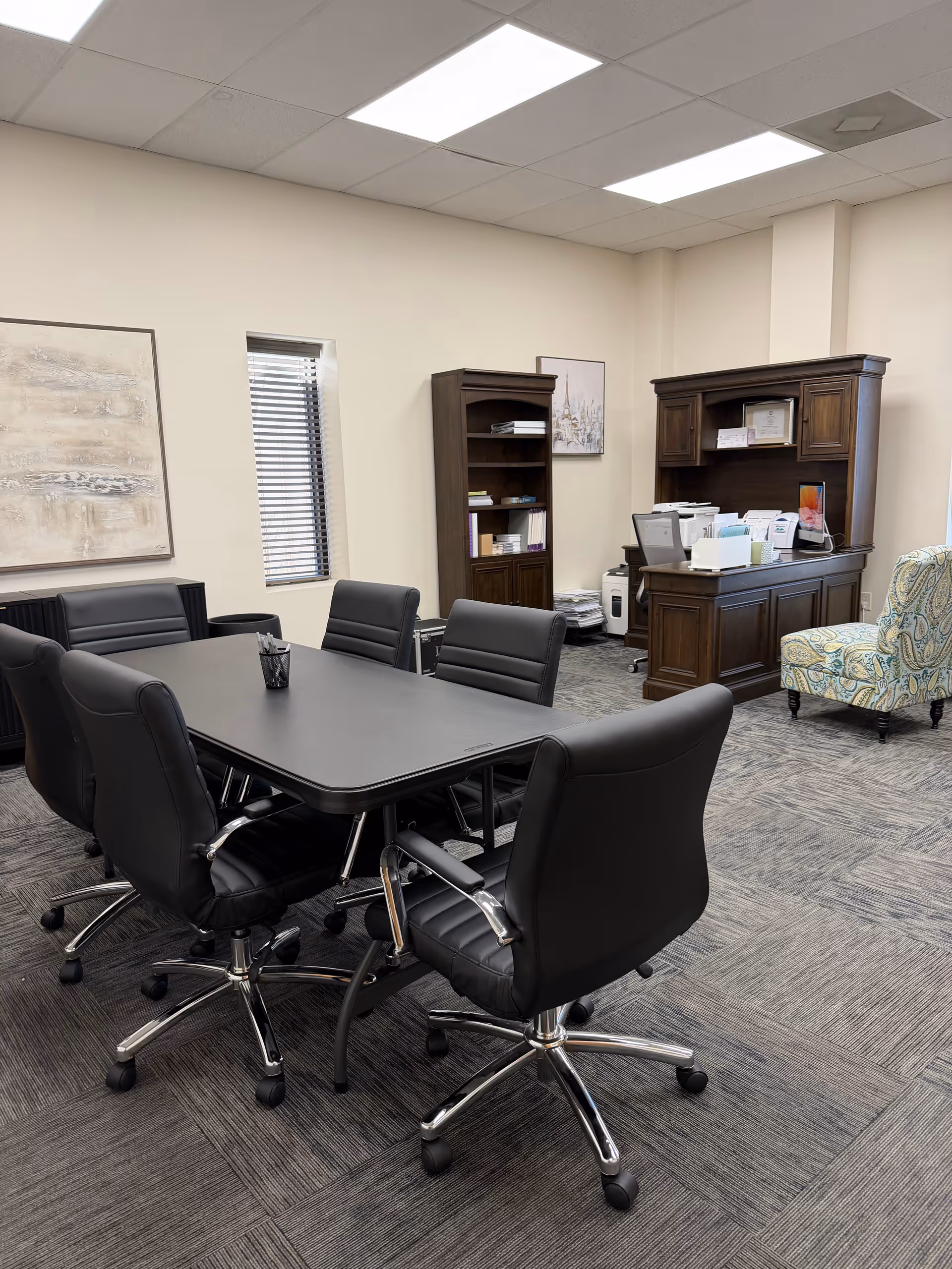 Conference room in a senior living facility featuring a large table and leather chairs.