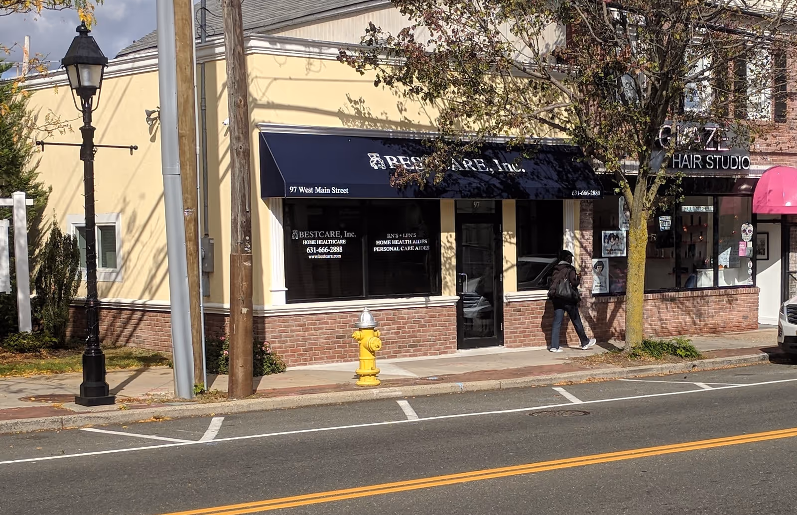 Exterior storefront of Best Care Inc on a city street with a passerby.