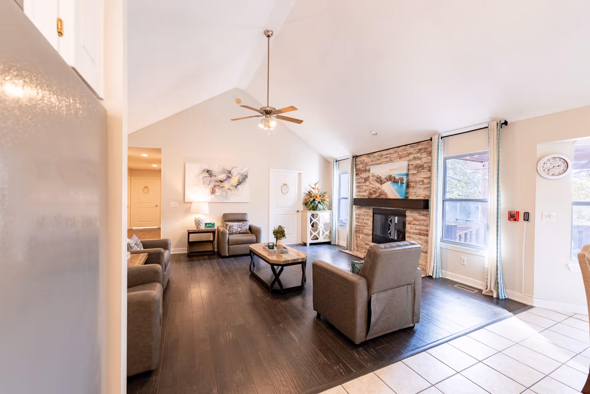 Spacious lounge area with couches around a coffee table and a brick fireplace.