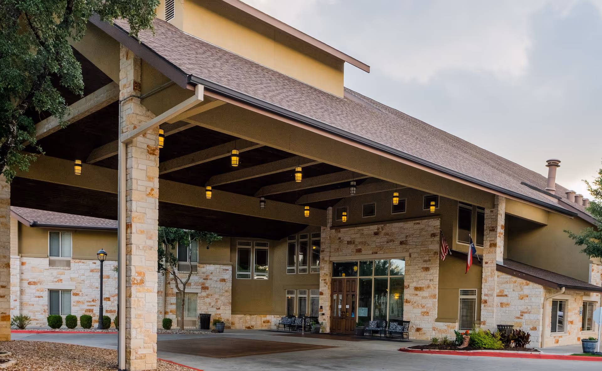 Exterior view of The Pavilion at Great Hills entrance with stone columns and a covered canopy.