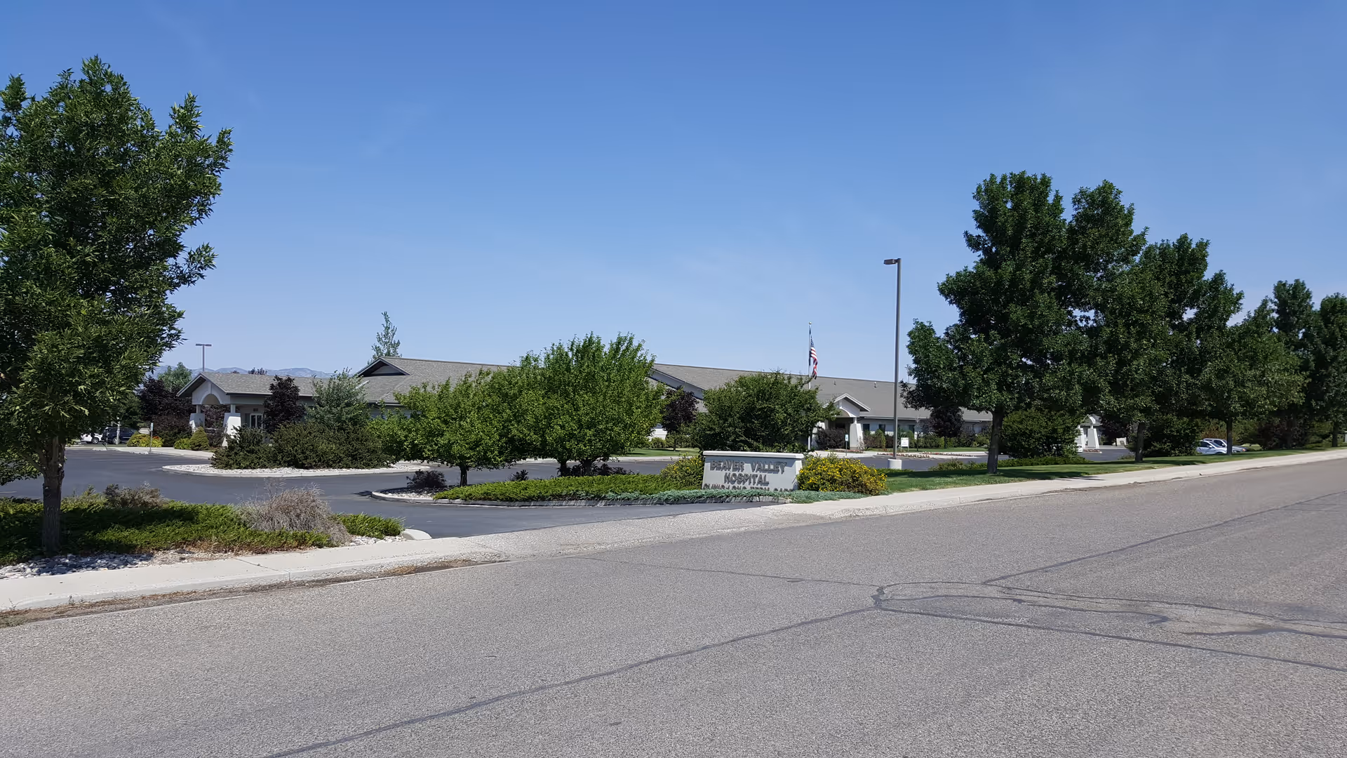 Beaver Valley Hospital exterior with trees, street, and sign.