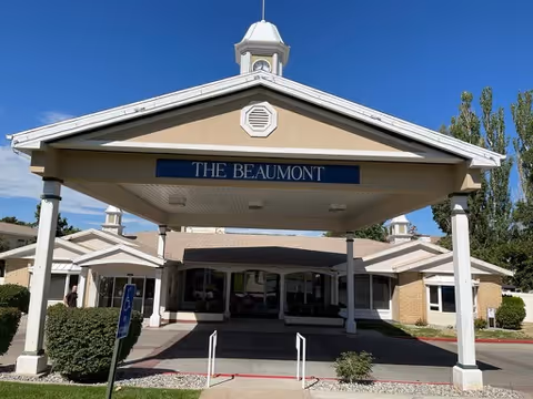 Front entrance of The Beaumont assisted living facility with a covered porte-cochère and a sign reading "THE BEAUMONT".
