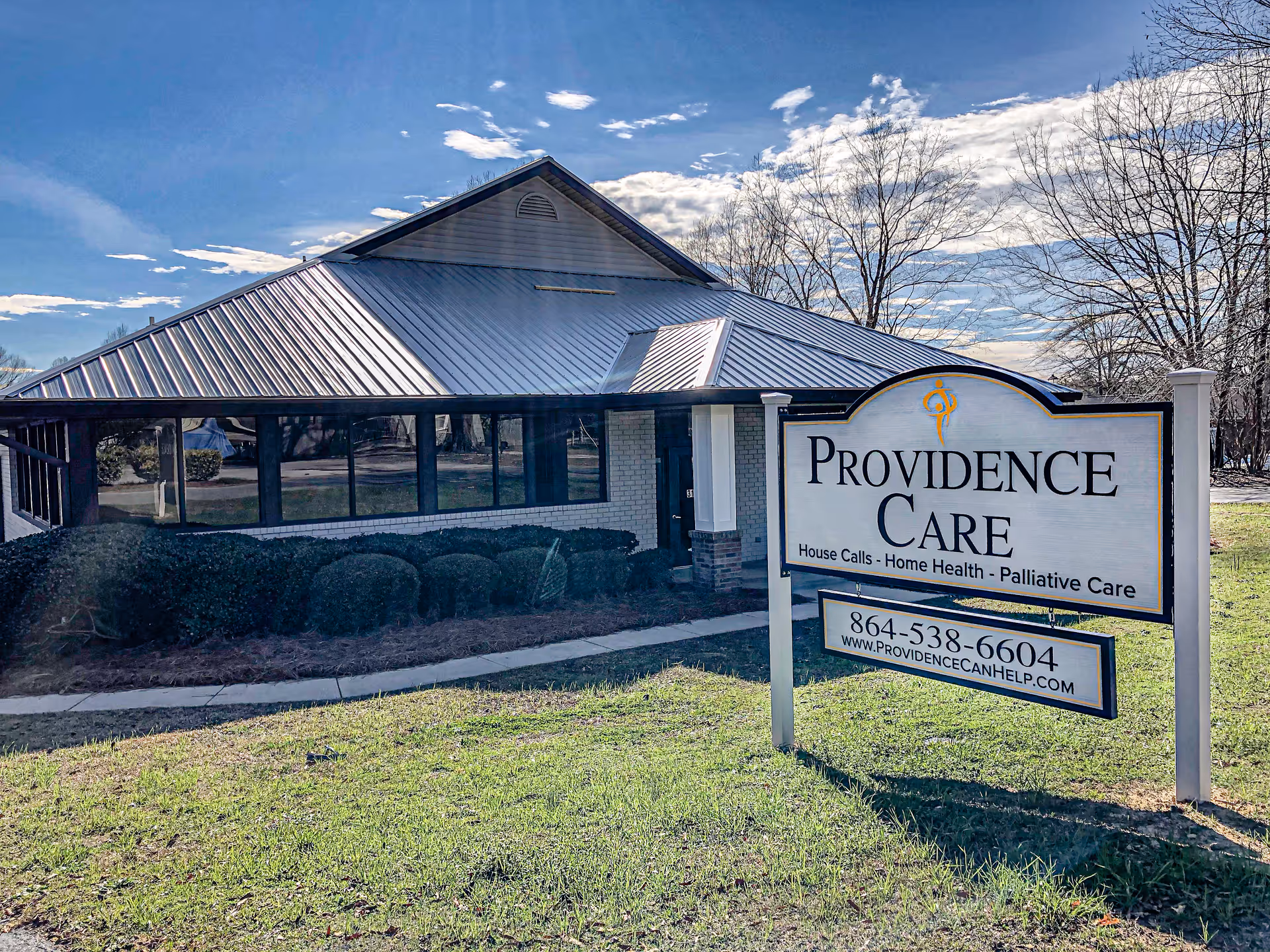 Exterior view of Providence Care facility with a large sign in front of a sloped-roof building.