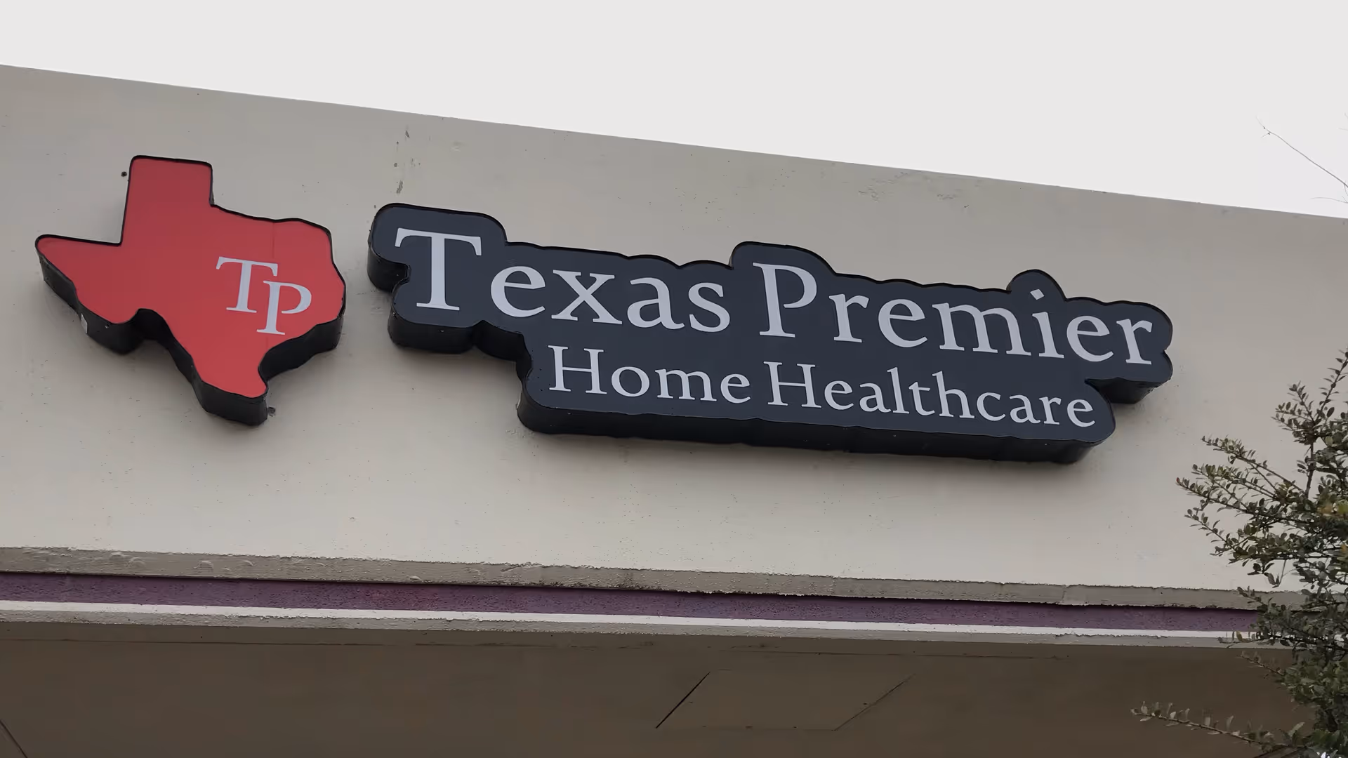 Sign on building exterior reading Texas Premier Home Healthcare with Texas-shaped logo.