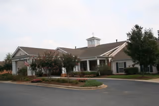 Front exterior view of Chandler Place Assisted Living building with landscaping and parking.