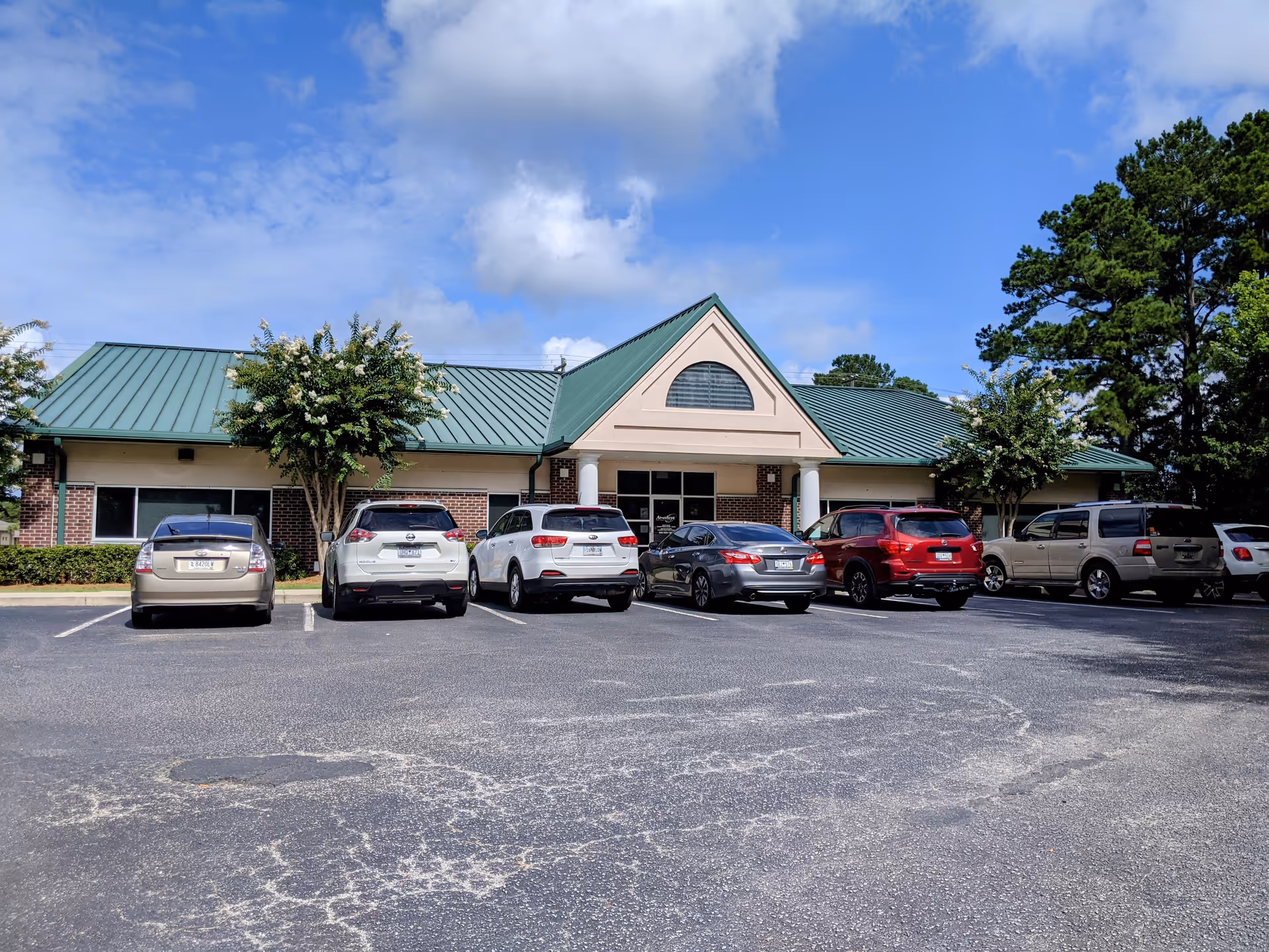 Amedisys Home Health Care building with a green roof and cars in front.