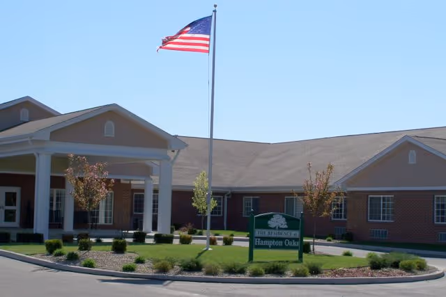 Front exterior of Hampton Oaks Health Campus with flagpole and porte-cochere.