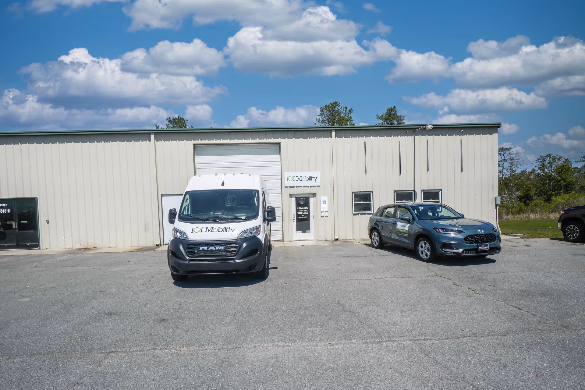 Exterior of a light metal building with two 101 Mobility vehicles in front.