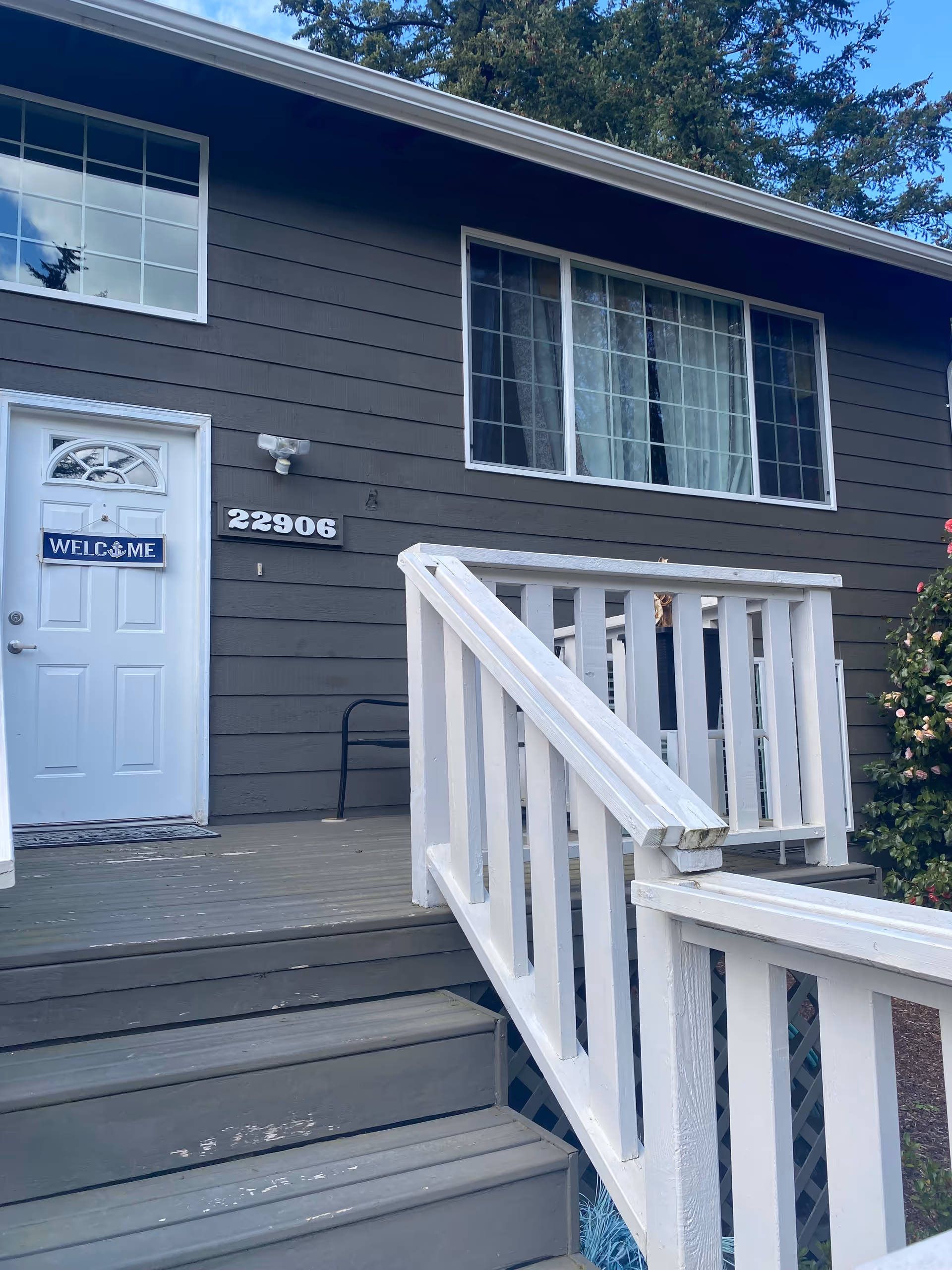 Exterior view of Brook Adult Family Home entrance with stairs and white railing.