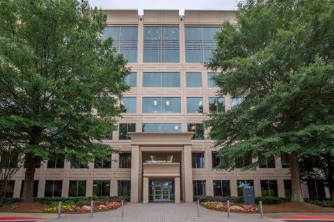 Exterior view of Castleton Home Care building entrance with landscaping and trees.