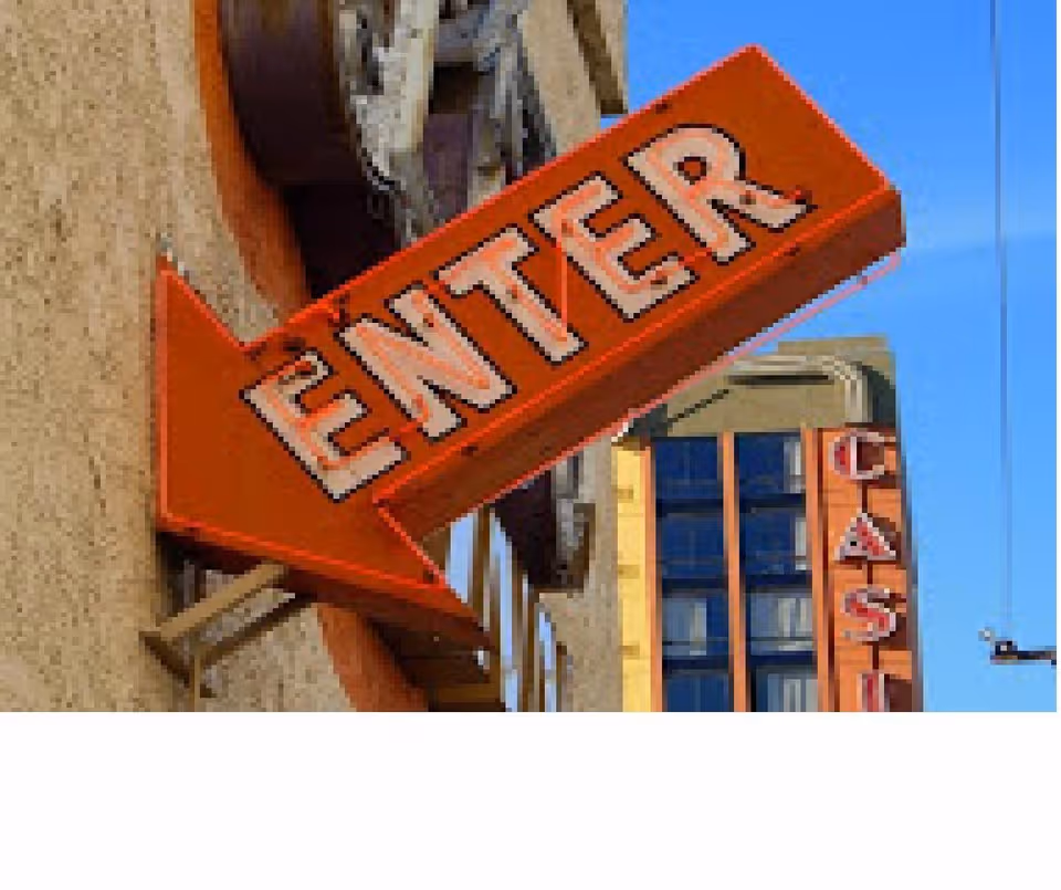 Orange entrance sign reading ENTER on a building exterior against a blue sky