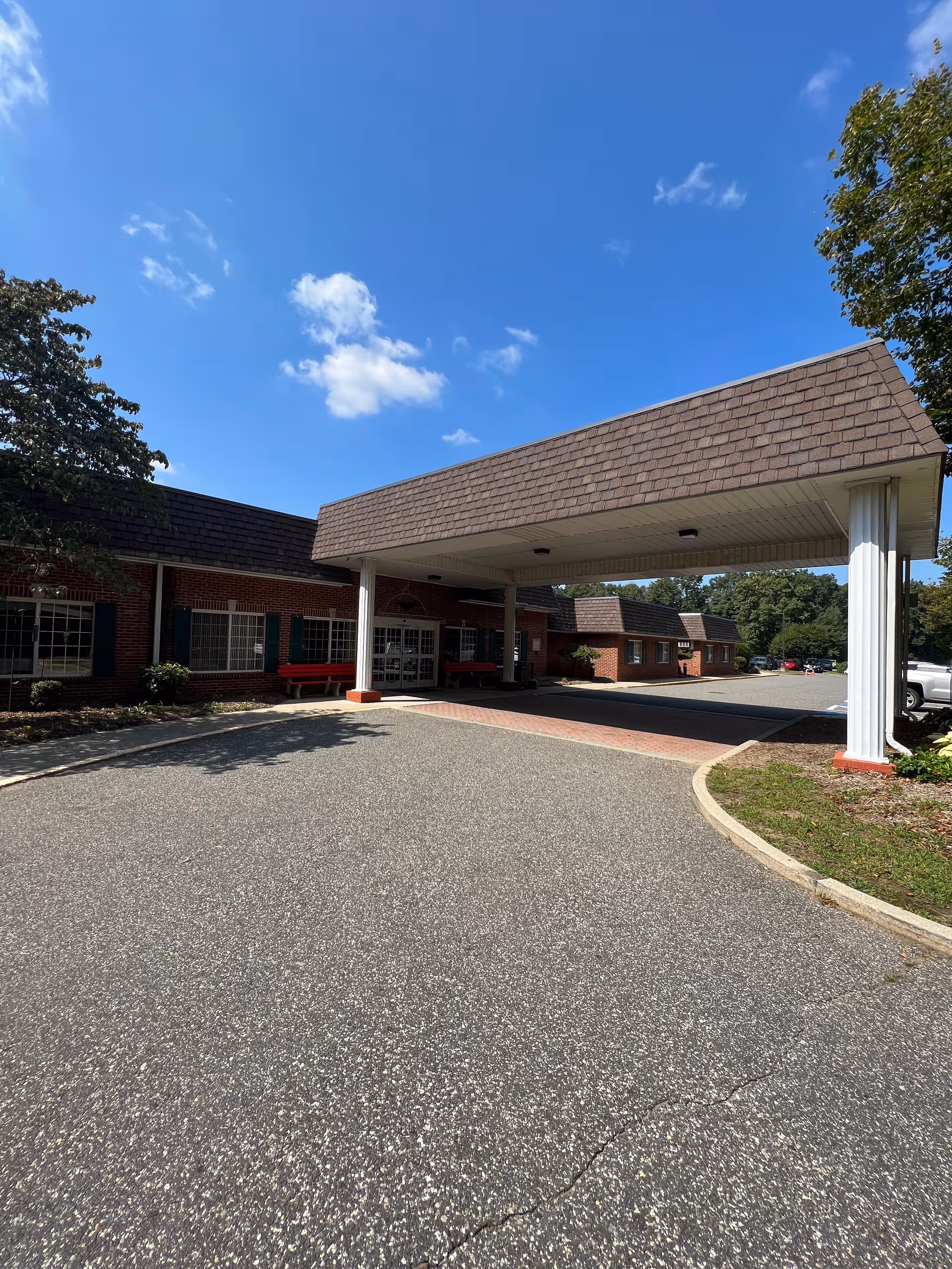 Wide driveway leads to Life Care Center of Wilbraham entrance under a covered portico.
