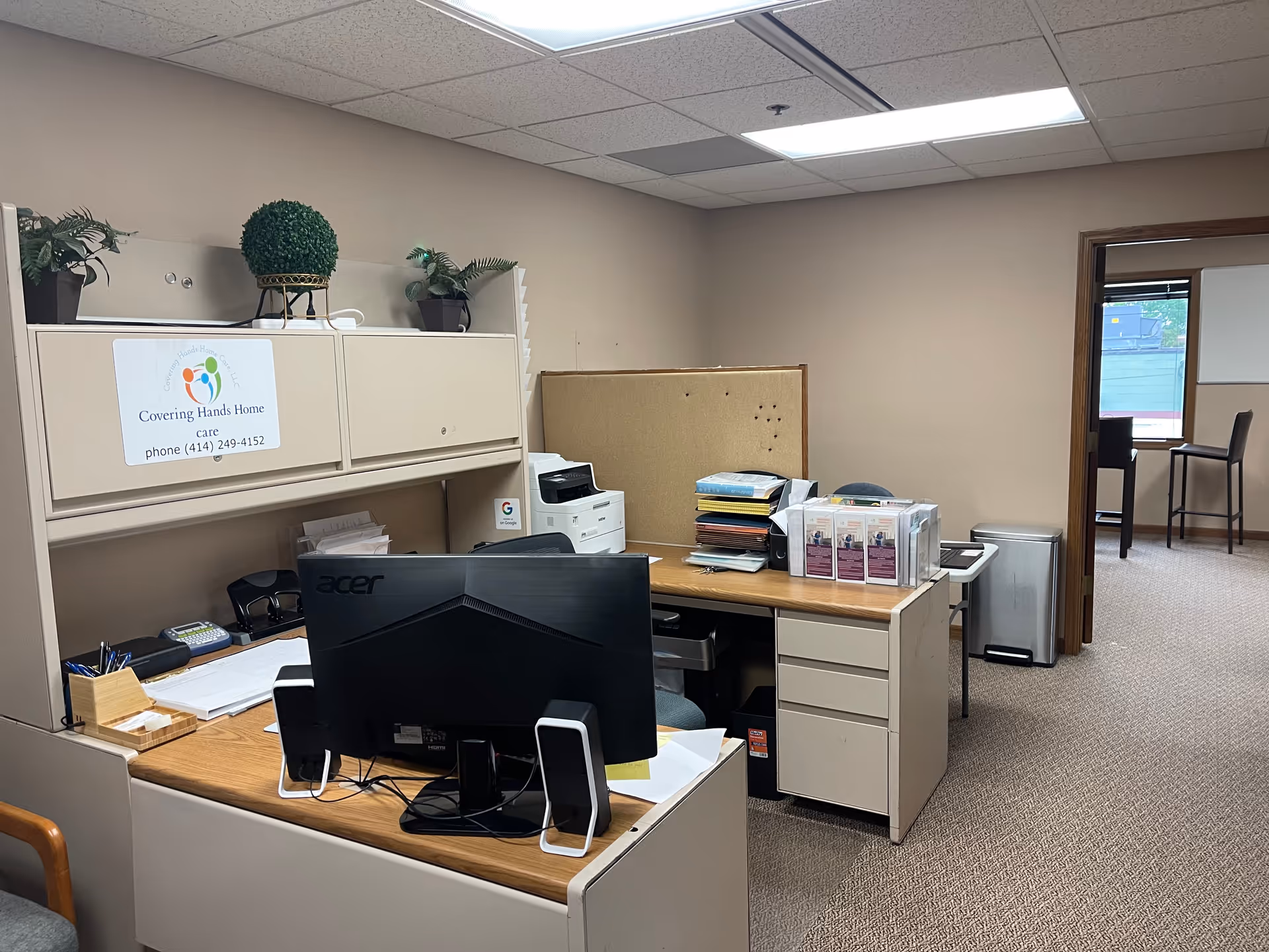 Office space in a senior care agency with desk, computer, printer, cabinets, and corkboard