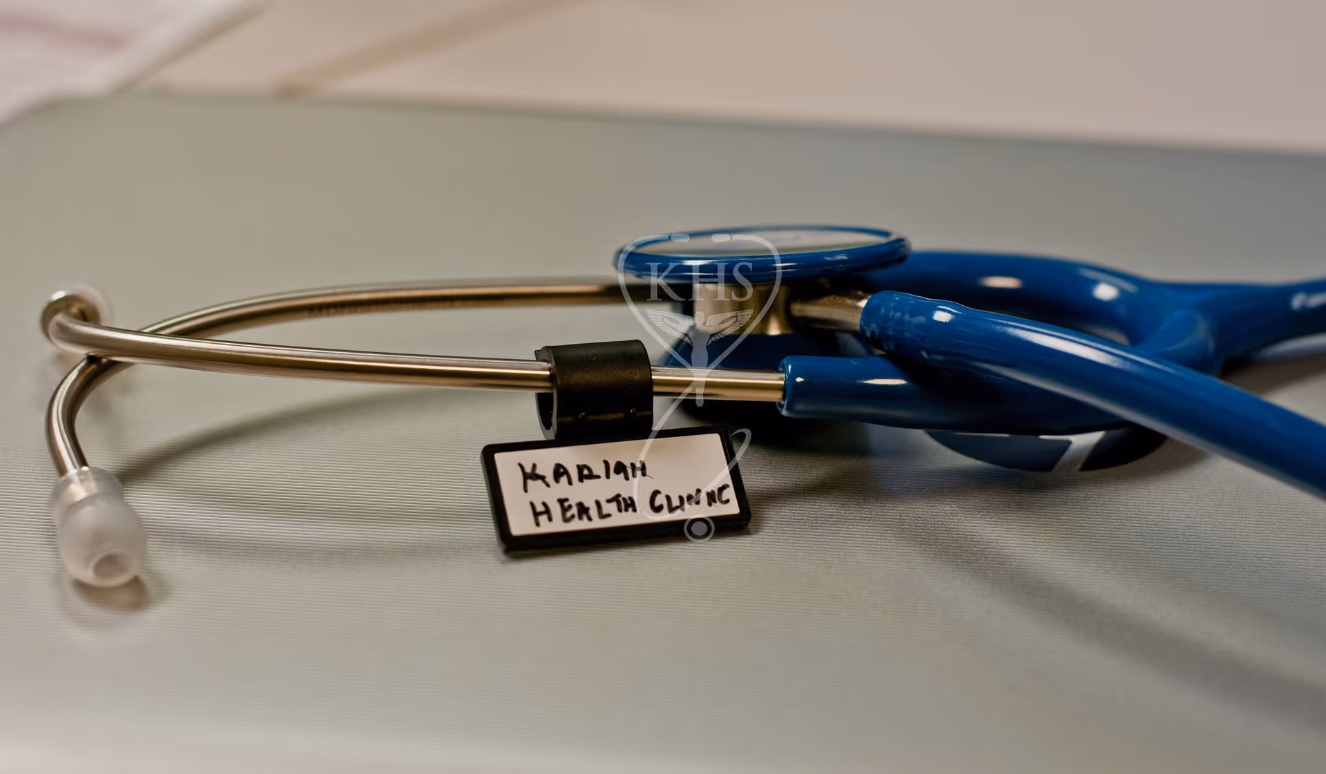 Close-up of stethoscope on a table with a label reading Kariah Health Clinic.