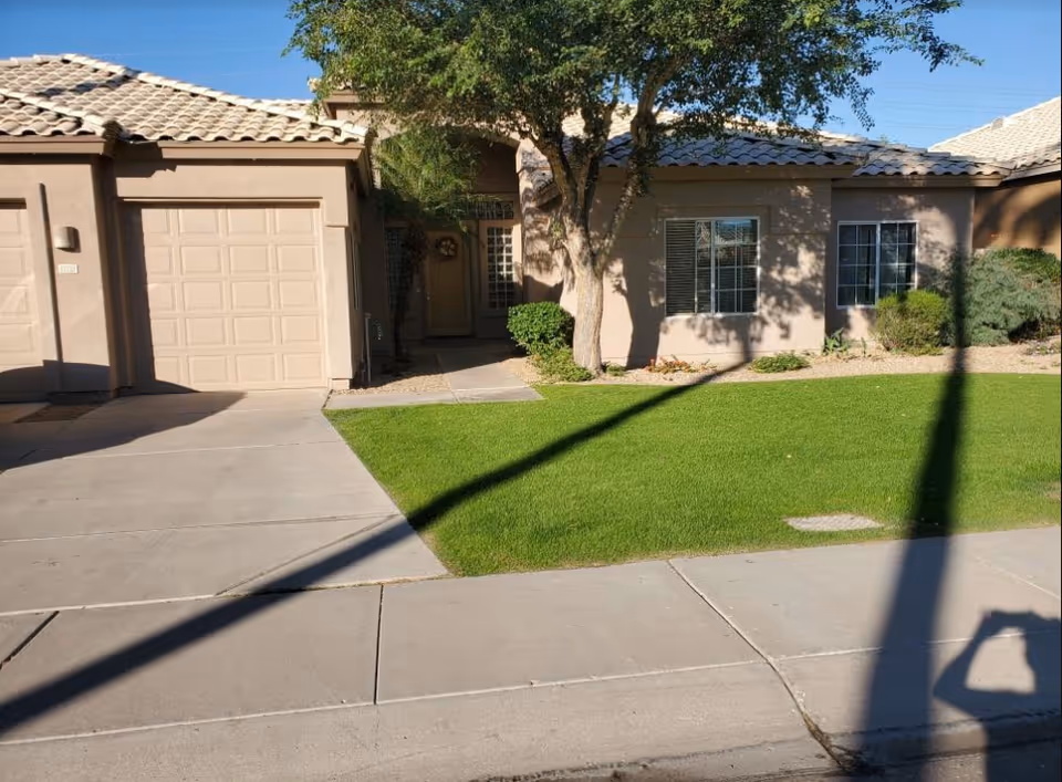 Front exterior of a single-story senior living residence with a lawn and driveway.