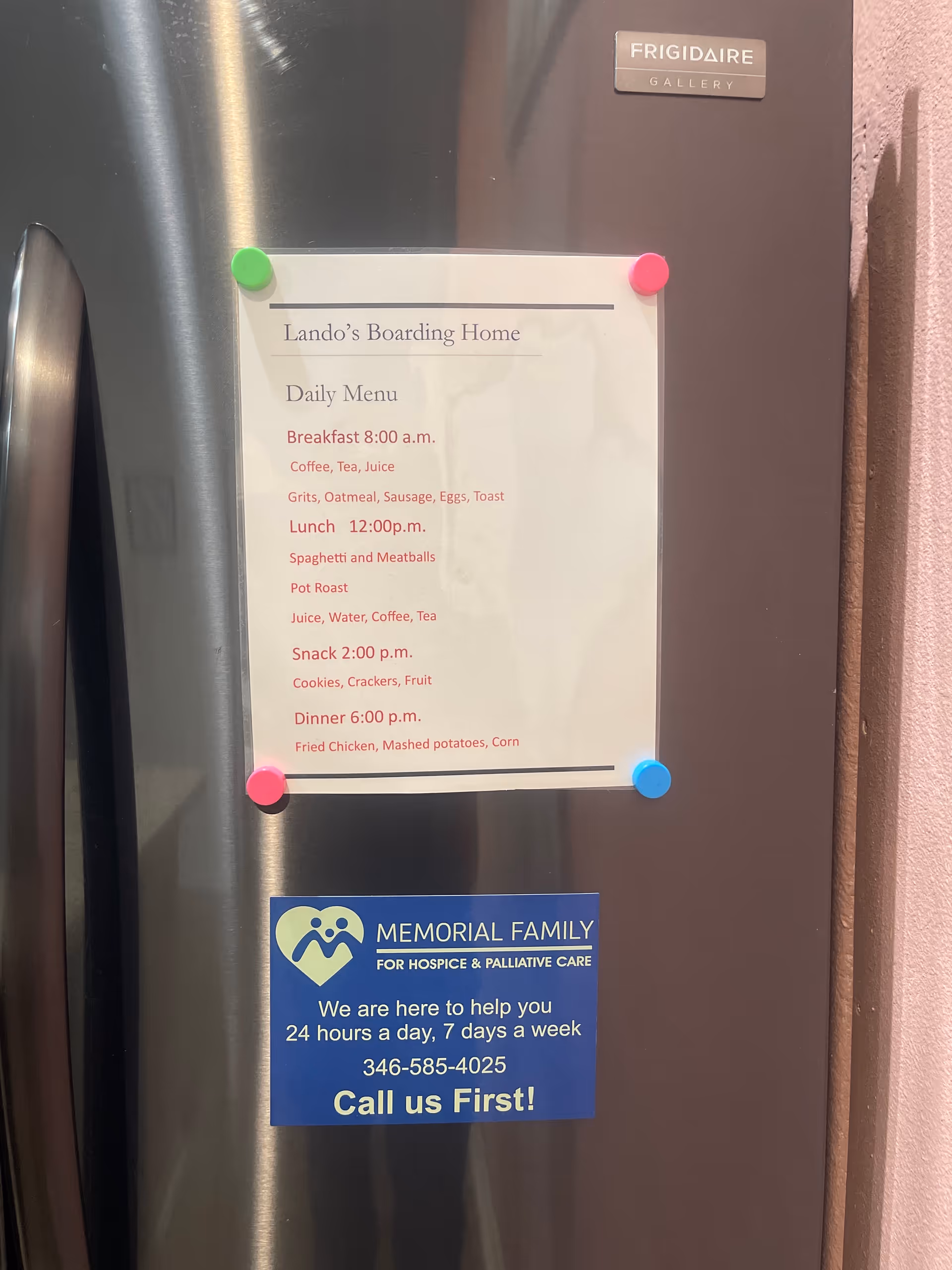 Stainless steel fridge with a posted daily menu and Memorial Family hospice care sign