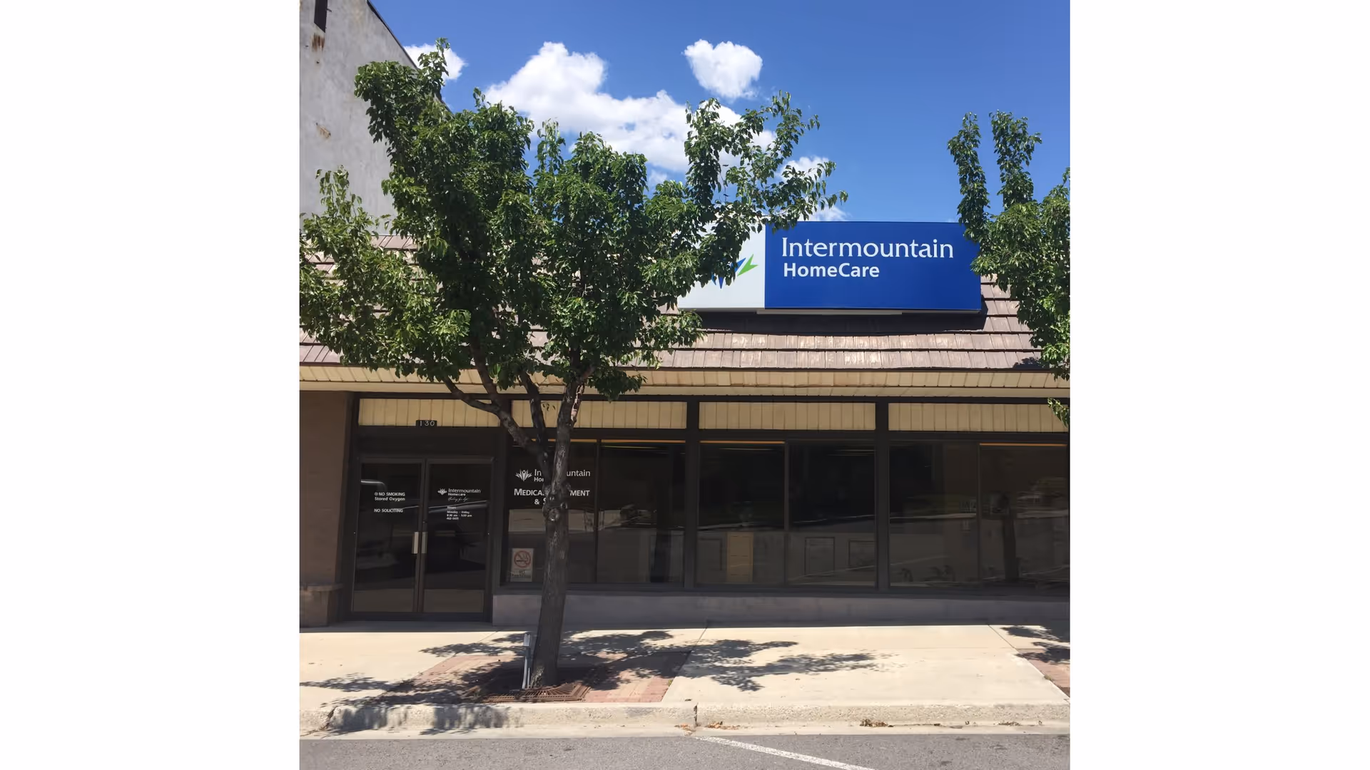 Exterior view of Intermountain HomeCare storefront with glass windows and a blue sign.