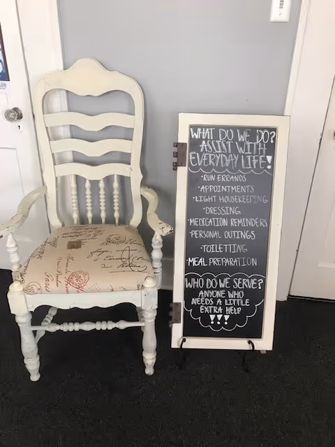 White ornate chair beside a chalkboard listing routine care tasks.