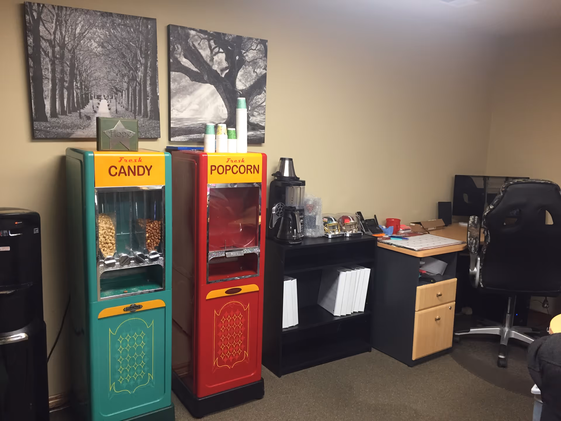 Interior staff lounge with candy and popcorn machines, a coffee station, and a desk.
