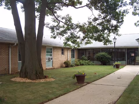 Exterior view of Lancashire Hall with walkway, trees, and planters by the entrance.