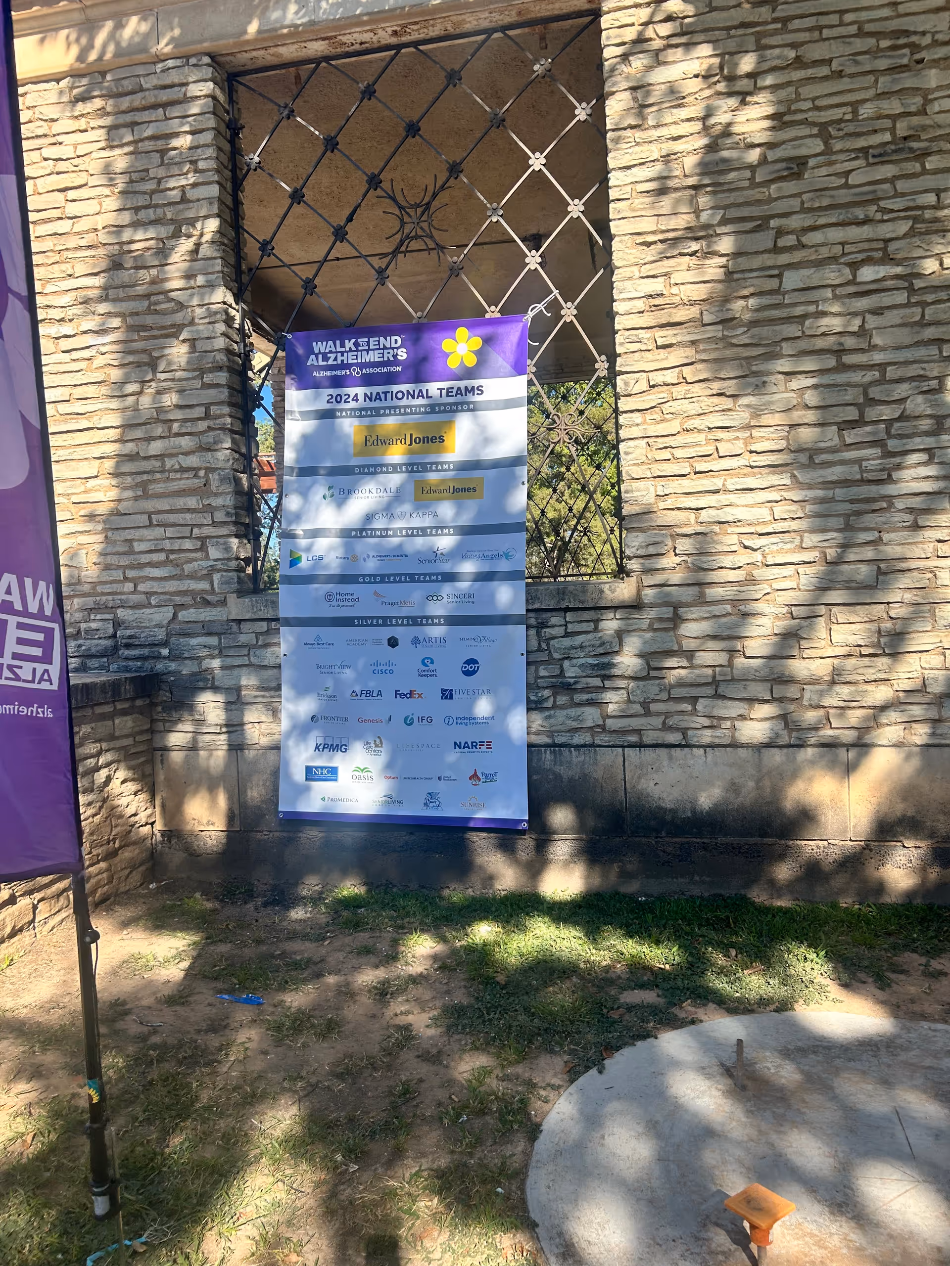 Exterior stone wall with Walk to End Alzheimer's banner and purple flag.