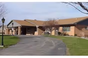 Single-story brick facility with a front entrance, driveway, and surrounding lawn.