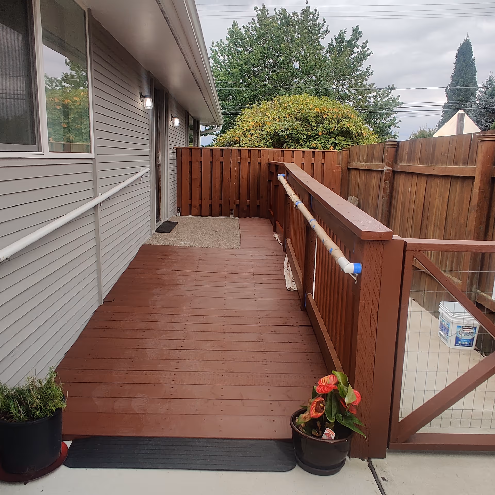 Back deck of Sapphire Adult Family Home with wooden railing and potted plants