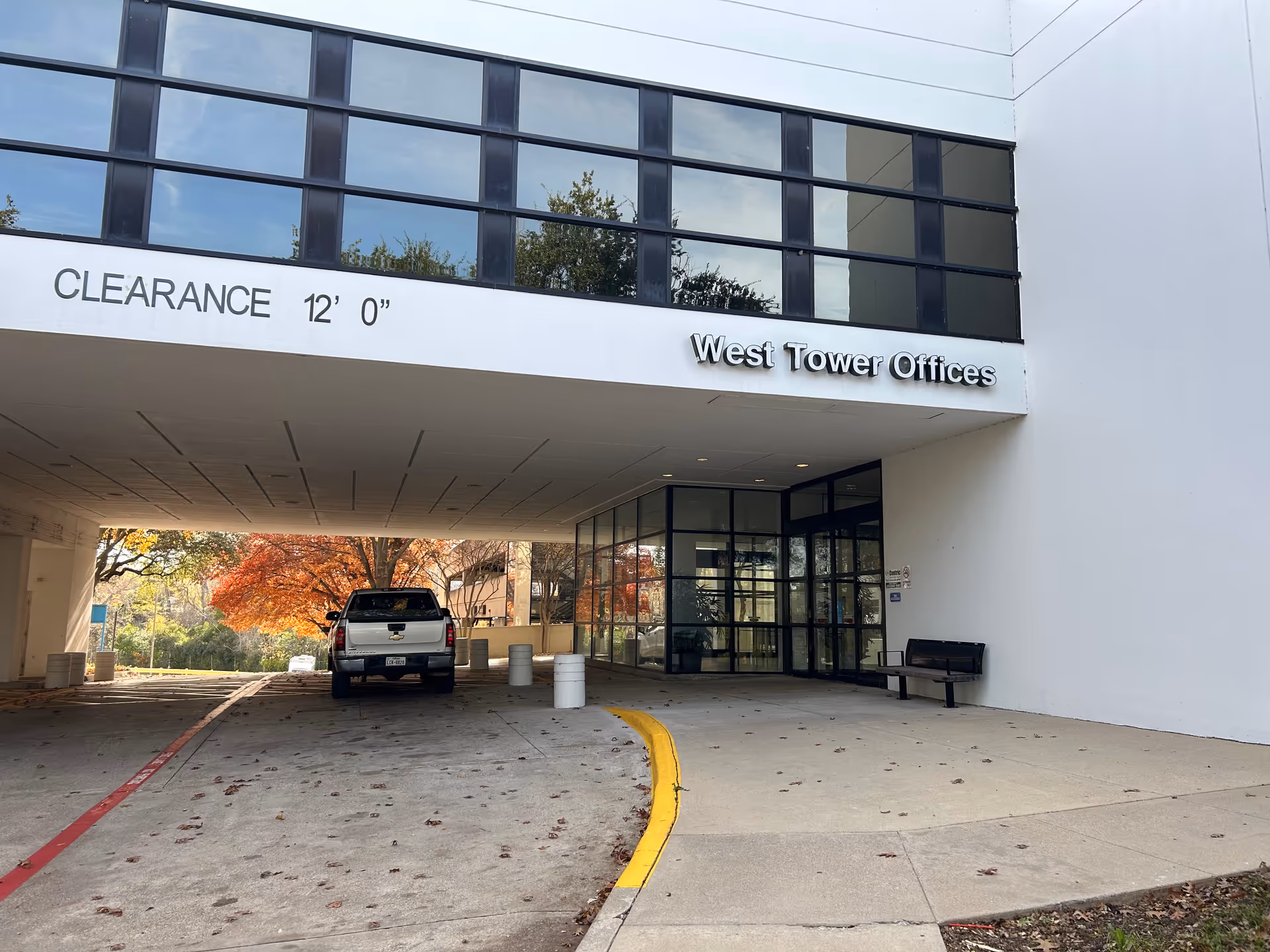 West Tower Offices entrance with glass doors and a vehicle in the driveway.