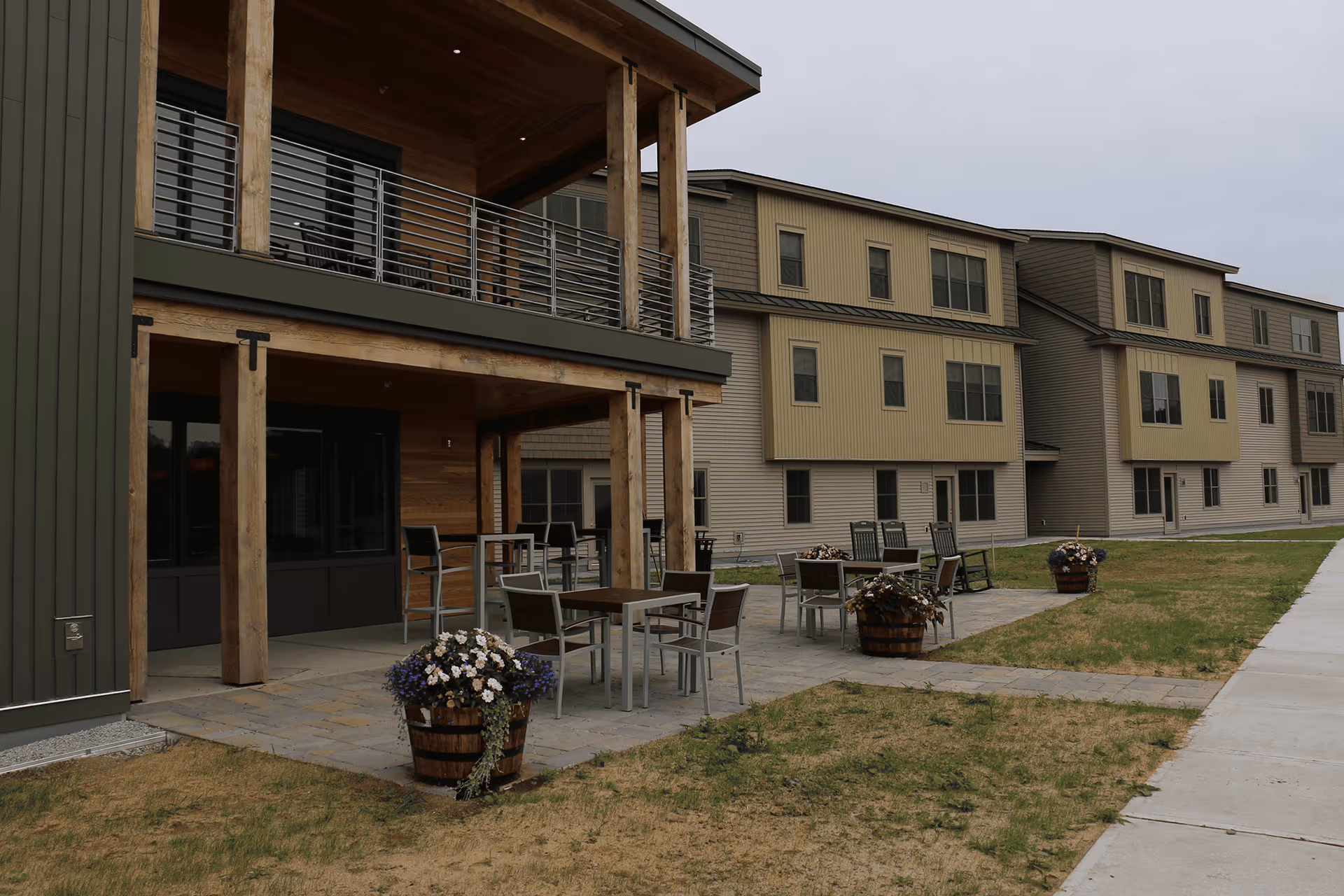 Exterior view of Strode Independent Living with patio seating and planters.