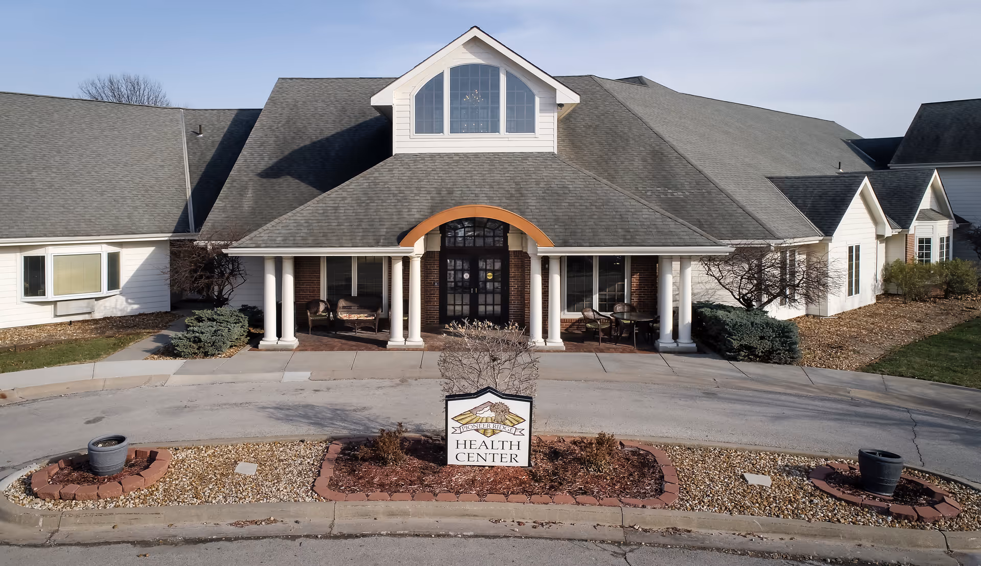 Front view of a single-story assisted living facility with a covered entrance.