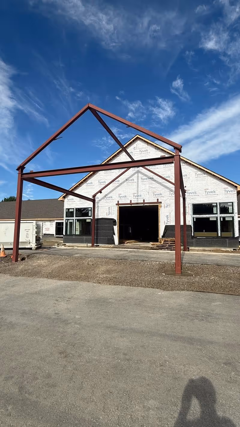 Front view of Grace Senior Living under construction with exposed framing and Tyvek wrap