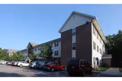 Exterior view of a multi-story senior living building with a parking lot.