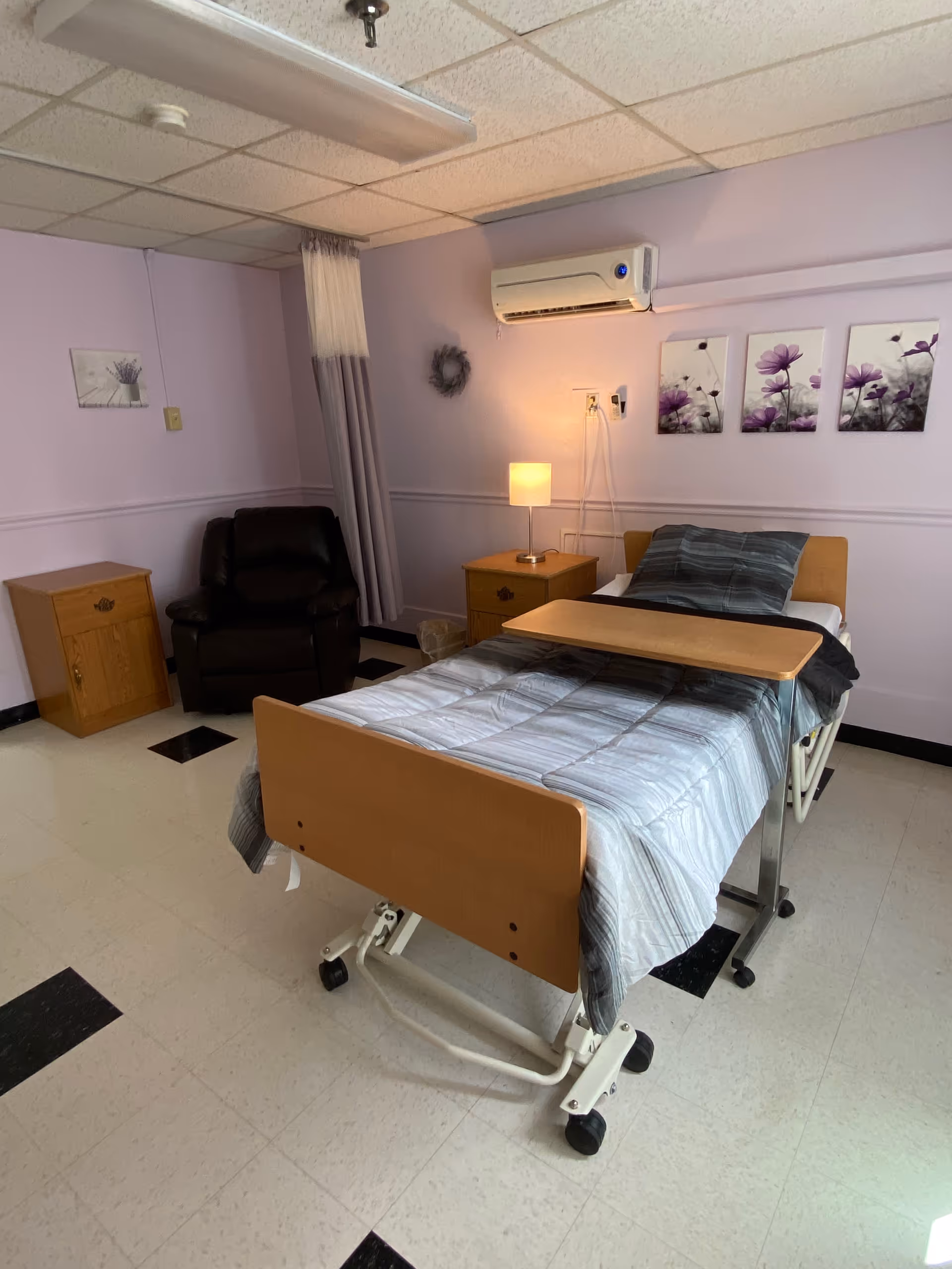 Patient bedroom in Golden LivingCenter - LaPorte with bed, chair, and purple walls.