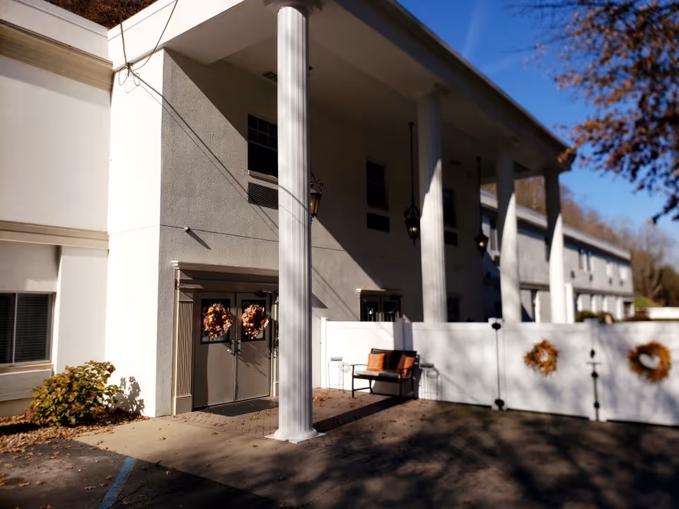Exterior of Kanawha Place senior living facility with columns and a bench.